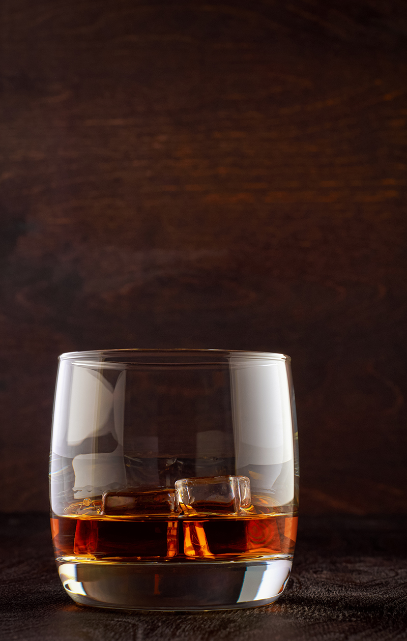 Glass of whiskey on a wooden table